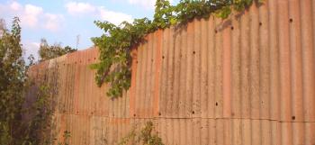 Висока ограда от материалите на стария навес